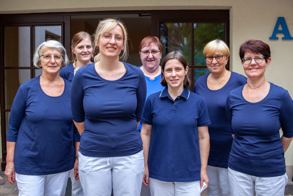 Das Team Landarztpraxis Nöbdenitz im September 2022 - in dunkelblauen T-Shirts vor der Praxis