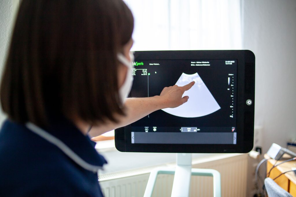 Ärztin der Landarztpraxis Nöbdenitz zeigt auf einen Ultraschallbildschirm